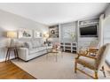 Stylish living room with hardwood floors, neutral walls, built-in shelving, and comfortable seating arrangement at 1714 Edgewater Dr, Charlotte, NC 28210