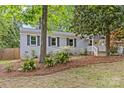 Charming home featuring a brick exterior, a welcoming front porch, and a lush landscaped yard at 3320 Eastwood Dr, Charlotte, NC 28205