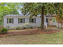 Charming home featuring a brick exterior, a welcoming front porch, and a mature shade tree at 3320 Eastwood Dr, Charlotte, NC 28205