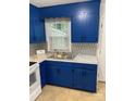 A cozy kitchen featuring stylish blue cabinets, patterned backsplash, and marble-look countertops at 4100 Howie Cir, Charlotte, NC 28205
