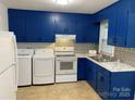 Bright kitchen showcasing blue cabinets, modern white appliances including a range, and tile flooring at 4100 Howie Cir, Charlotte, NC 28205