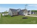 Well-maintained home with blue siding, stone accents, green lawn, and tree at 4205 Jones Creek Ln, Charlotte, NC 28215