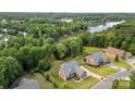 Stunning aerial view of a brick home with a long driveway, set amidst lush greenery and lake access at 444 Snapdragon Dr, Clover, SC 29710