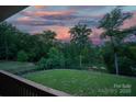 Expansive backyard featuring lush grass, mature trees, and a tranquil view from the upper deck at 444 Snapdragon Dr, Clover, SC 29710