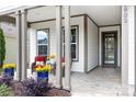 Inviting covered porch features chairs and blue flower pots with yellow flowers at 4902 Looking Glass Trl, Denver, NC 28037