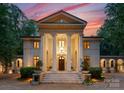 Impressive facade showcasing stately columns, an elegant entrance, and meticulous landscaping at twilight at 5030 Hardison Rd, Charlotte, NC 28226