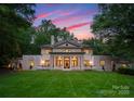 Beautiful home with a spacious lawn, classic architectural design, and inviting curb appeal during twilight at 5030 Hardison Rd, Charlotte, NC 28226