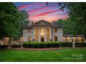 Elegant home featuring grand columns, well-maintained landscaping, and a serene setting at dusk at 5030 Hardison Rd, Charlotte, NC 28226