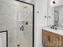 Modern bathroom features frameless glass shower with white herringbone tile and light wood vanity at 6009 Countess Dr # 50, Charlotte, NC 28217