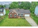 Aerial view of a brick home featuring an attached two car garage and a well-maintained yard at 616 Trailing Rock Dr, Charlotte, NC 28214
