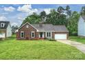 Charming brick home with a lush green lawn and an attached two car garage at 616 Trailing Rock Dr, Charlotte, NC 28214