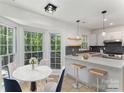 Cozy breakfast nook featuring a bay window, a dining table, and a breakfast bar with modern pendant lighting at 7212 Canyon Dr, Charlotte, NC 28262