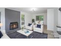 Bright living room featuring a gray fireplace, comfortable seating, and a dining area with access to the outdoors at 7212 Canyon Dr, Charlotte, NC 28262