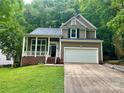Charming two-story home with a white garage door, covered porch, and well-manicured lawn at 7401 Kinsmore Ln, Charlotte, NC 28269