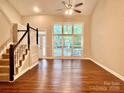 Bright living room with hardwood floors, a staircase, and large windows offering ample natural light at 7401 Kinsmore Ln, Charlotte, NC 28269