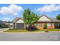 Beautiful single-story brick home with a screened porch, landscaping, and a tree-lined street at 8473 Bing Cherry Dr, Denver, NC 28037