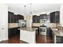 Well-equipped kitchen features stainless appliances, granite counters, and rich wood flooring at 10417 Ebbets Rd, Charlotte, NC 28273
