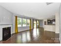 Bright living room features fireplace, hardwood floors, and a wall of sunny windows at 10417 Ebbets Rd, Charlotte, NC 28273