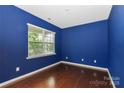 This room has dark blue walls and dark hardwood flooring with a window at 10417 Ebbets Rd, Charlotte, NC 28273