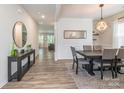 Elegant dining room featuring modern chandelier, sleek table with six chairs, and wood-look flooring at 115 Haddonsfield Dr, Mooresville, NC 28115