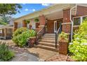 Inviting brick porch with stone accents, wrought iron railings, and lush landscaping creates a welcoming entrance at 119 Wiley Ave, Salisbury, NC 28144
