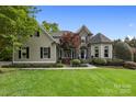 Charming home with lush lawn, mature landscaping, stone accents, and inviting curb appeal at 18730 Floyd Ct, Davidson, NC 28036