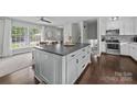 Open kitchen featuring a large center island with dark countertops, hardwood floors, and modern appliances at 2100 Shadyview Dr, Charlotte, NC 28210