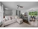 Open living area features a comfortable sofa, ceiling fan, and an eat-in kitchen with a large window at 2100 Shadyview Dr, Charlotte, NC 28210