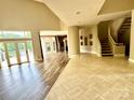 Spacious living room featuring sleek wood floors, winding staircase, high ceilings, and water views at 255 Charlotte Ann Ln, Hickory, NC 28601