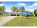 Charming blue home featuring a covered carport, landscaped lawn, and white-trimmed windows at 2649 Tiffany St, Conover, NC 28613