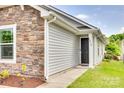 Inviting front entrance with a black door, stone accents, and well-maintained landscaping at 2810 Berry Creek Rd, Charlotte, NC 28214