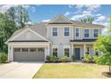 Charming two-story home with a gray exterior, two-car garage, landscaped yard, and inviting front porch at 3925 Tokay Ln, Fort Mill, SC 29707