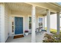Inviting front porch with blue door, seating, and well-manicured landscaping and the address 3925 at 3925 Tokay Ln, Fort Mill, SC 29707