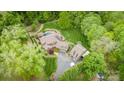 An aerial view of a luxurious home with a pool, complemented by a perfectly manicured lawn and lush landscaping at 4600 Spicewood Dr, Charlotte, NC 28227