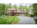 A stately brick home boasts a lush, landscaped yard, a convenient two-car garage, and a charming covered carport at 4600 Spicewood Dr, Charlotte, NC 28227