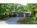 A cozy one-story home with brick facade and light siding, complemented by a gravel driveway at 634 7Th Avenue Se Pl, Hickory, NC 28602