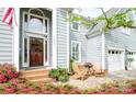 Inviting front porch with a seating area, beautiful flowerbeds, and a stylish front door at 6425 High Creek Ct, Charlotte, NC 28277