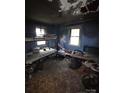 Heavily damaged bedroom featuring two beds, peeling blue walls, and water damaged floors at 721 S Spruce St, Rock Hill, SC 29730
