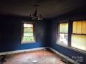 View of fire damage in a living room with hardwood floors, three windows and a ceiling fan at 721 S Spruce St, Rock Hill, SC 29730