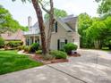 Beautiful home featuring a large driveway, lush landscaping, and classic architectural details at 7716 Seton House Ln, Charlotte, NC 28277