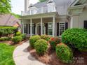 Inviting front exterior with manicured bushes and flowerbeds along the walkway to the front door at 7716 Seton House Ln, Charlotte, NC 28277