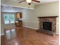 Inviting living room with brick fireplace, wood floors, and bright natural light from large windows at 8000 Tiburon Cir, Charlotte, NC 28215