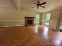 Bright living room boasts a brick fireplace, wood flooring and lots of natural light through large windows at 8000 Tiburon Cir, Charlotte, NC 28215