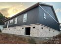 New construction home with dark blue exterior and white brick base; long view of the side and back of the house at 85 Cornerstone Dr, Taylorsville, NC 28681