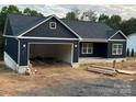 Stylish home with a modern garage and dark siding, adding to its curb appeal at 85 Cornerstone Dr, Taylorsville, NC 28681