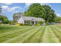 Quaint one-story home featuring manicured lawn and landscaping, with trees in the background at 878 Cold Springs Rd, Concord, NC 28025