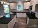 Stylish modern kitchen with white cabinets, subway tile backsplash, and sleek black countertops at 901 3Rd St, Spencer, NC 28159