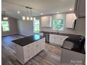 Bright kitchen features an island with a dark countertop, stainless steel appliances, and white cabinets at 901 3Rd St, Spencer, NC 28159