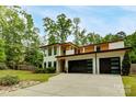 Stunning modern home with a three-car garage, accented by mature trees and landscaping at 9305 Valley Rd, Charlotte, NC 28270