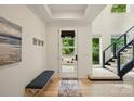 Bright foyer featuring an entry bench, modern staircase, and hardwood flooring at 9305 Valley Rd, Charlotte, NC 28270